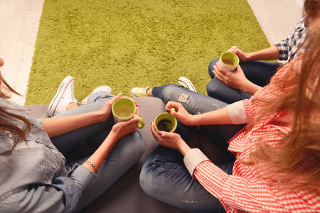 Top view photo of three women sitting on couch with cupsの写真素材