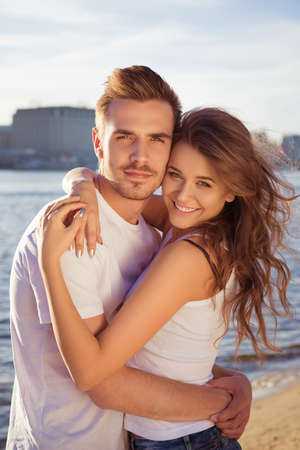 Close up portrait of happy smiling couple embracing at the beachの写真素材