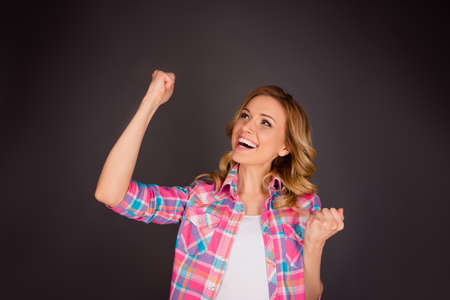 Successful pretty  woman triumphing with raised fists