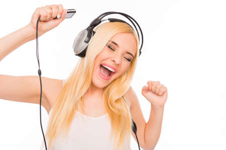 Cheerful lady with mp3 and headphones listening music and dancingの写真素材