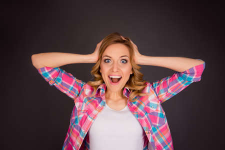 Surprised happy young woman touching her head and screamingの写真素材