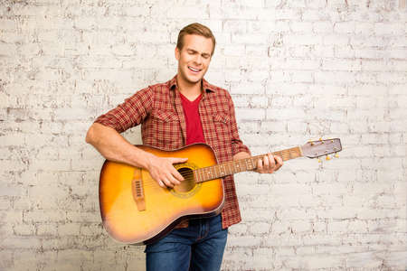 Young successful musician playing on guitar and singingの写真素材