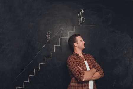 Succseful young man reaching the goal to become richの写真素材