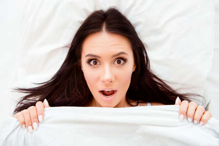 Top view portrait of shocked woman with open mouth after sleep