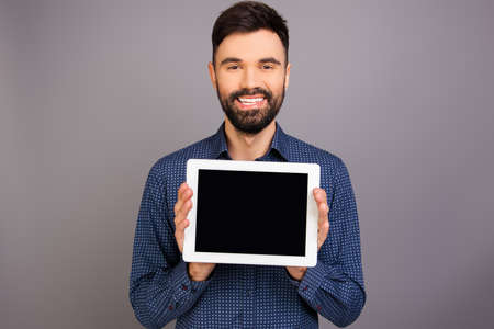 Cheerful handsome man demonstrating black screen of tablet