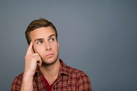 Young handsome minded man trying to find way to solve problemの写真素材