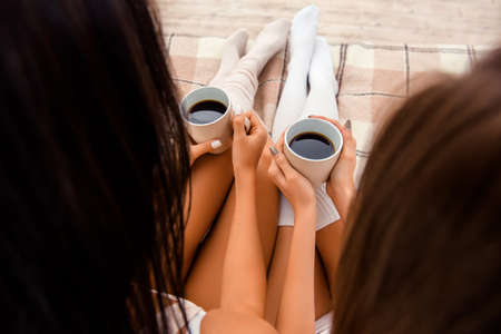 Close up photo of two cups of coffee in hands, top view pointの写真素材
