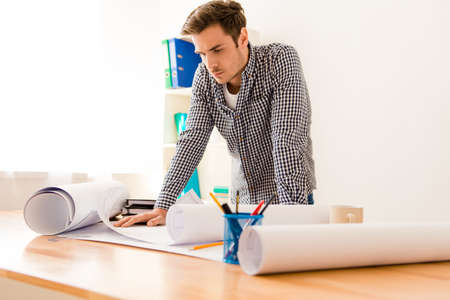 Portrait of a handsome guy in his office working on project