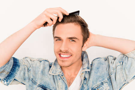 Handsome cheerful young guy doing modern hairstyle