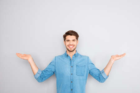 Young happy man gesturing with hands and showing balanceの写真素材