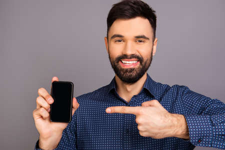 Portrait of  happy man showing black screen of his smartphoneの写真素材