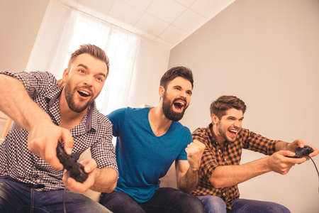 Yeah! excited happy cheerful men play video game with his friendsの写真素材