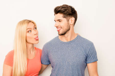 Portrait of comic man and woman showing tongues to each other