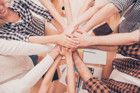 top view closeup photo of businesspeople  putting their hands on top of each other  at conferenceの写真素材