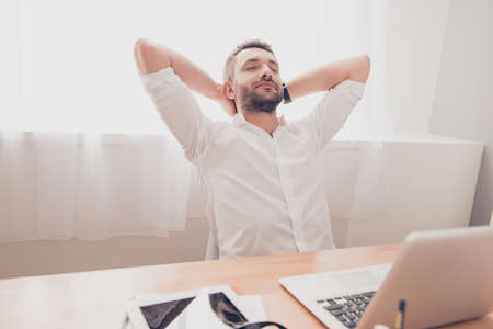 Tired bearded worker having break and resting after workの写真素材