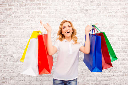 Happy woman with paperbags doing shopping in the mall