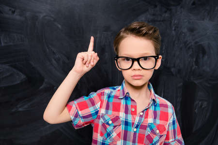 Smart little school boy in glasses having an idea