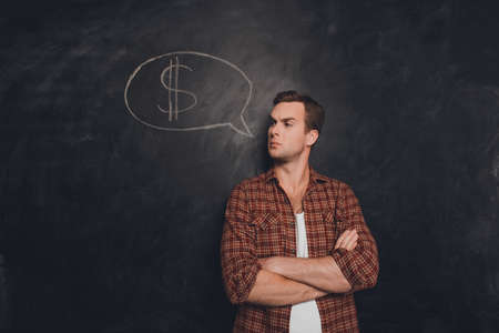 Serious businessman with crossed hands thinking how to earn moneyの写真素材