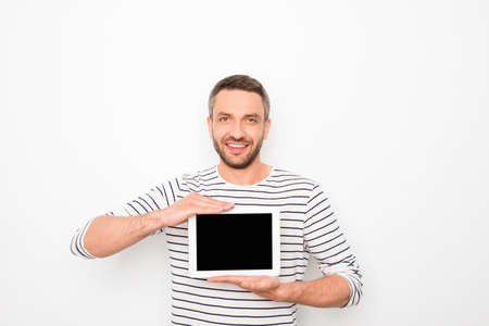 Cheerful handsome guy demonstrating black screen of tablet