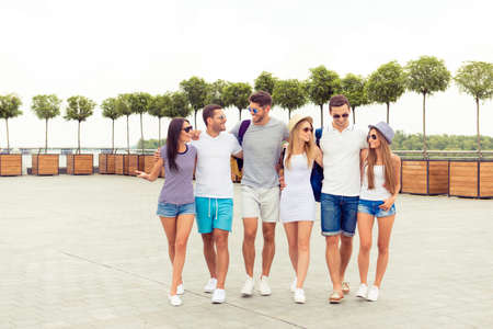 joyful happy young people talking and  walking square of cityの写真素材