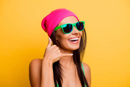 Portrait of attractive happy girl with glasses gesturing with fingers call meの写真素材