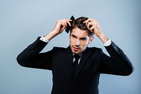 Portrait of handsome young businessman combing his hairの写真素材