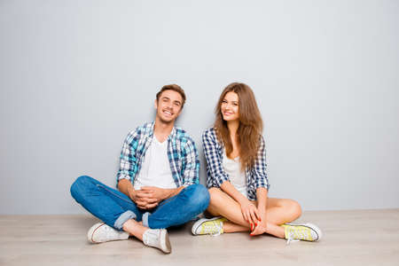 happy young smiling couple in love sitting floorの写真素材