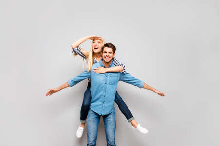 Cheerful couple in love traveling. Happy man carrying his smiling girlfriend on the backの写真素材