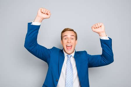 Portrait of happy businessman celebrating victory with raised hands