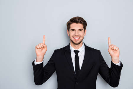 Handsome smiling man in suit gesturing up with fingers