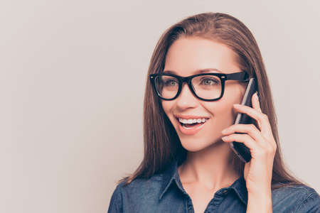 Portrait of beautiful woman in glasses talking  on mobile phoneの写真素材