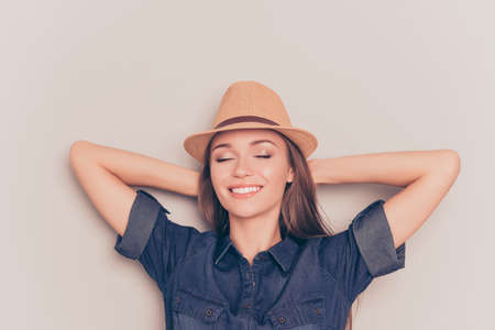 Young relaxed woman with closed eyes touching head and dreamingの写真素材