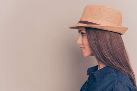 Side view portrait of beautiful woman in summer hat on gray backgroundの写真素材