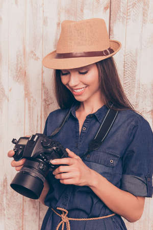Professional happy photographer holding camera and looking on photosの写真素材