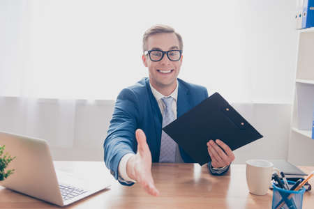 Happy businessman giving hand for handshake to make finansial dealの写真素材