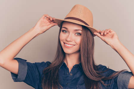 Portrait of cheerful girl touching her hat with both handsの写真素材