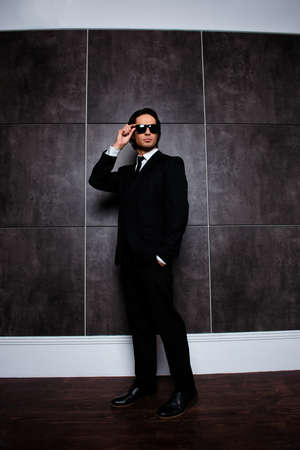 full height photo of serious stylish  man holding glassesの写真素材