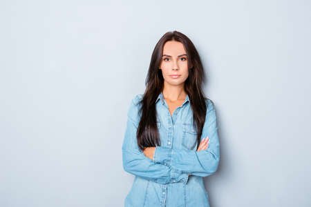 Young happy woman with crossed hands isolated on gray backgroundの写真素材