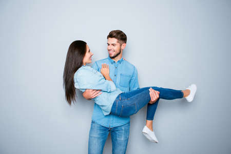 Happy smiling young man carrying his pretty girlfriendの写真素材