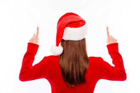 Back view of  young brunette in santa hat gesturing upの写真素材