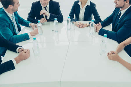 Close up of group of business people sitting around table at meetingの写真素材