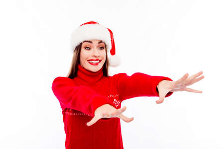 Excited girl in santa hat trying to catch xmas presents