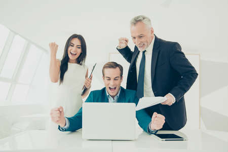 Happy smiling businesspeople triumphing with raised fistsの写真素材