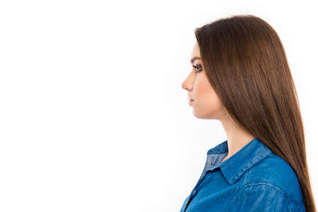 Profile of young pretty confident brunette woman in jean shirtの写真素材