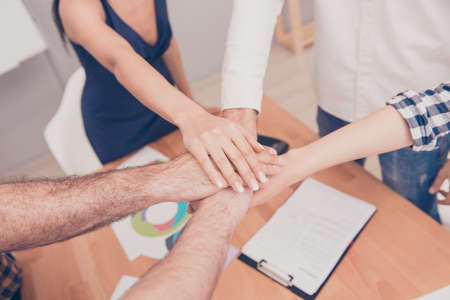 Close up of group of businesspeople putting their hands on top of each otherの写真素材