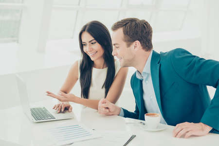 Happy businesswoman showing  financial report on her laptop to colleague