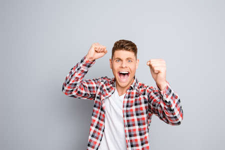 Excited happy successful man triumphing and showing fistsの写真素材