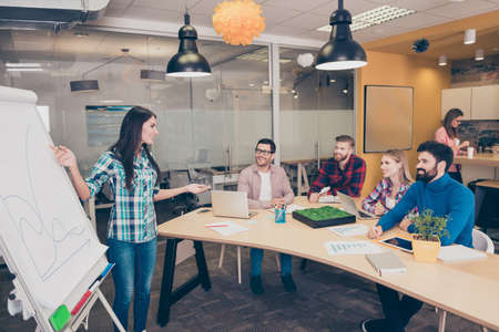 Young woman near whiteboard making presentation about growth of company
