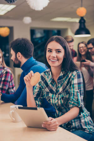 Happy woman drinking coffe while her friends, having fun on break and using tabletの写真素材