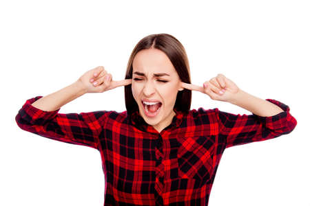Angry upset  woman covering ears with fingers and screaming